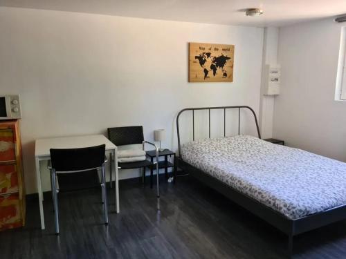 a bedroom with a bed and a table and chairs at Charmant studio à Saint-Ay, 25 m², avec vue sur le jardin in Saint-Ay