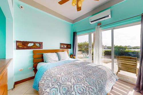 サン・ペドロにあるSuite B101 at Mara Laguna Gold Standard Certifiedの青いベッドルーム(ベッド1台、大きな窓付)