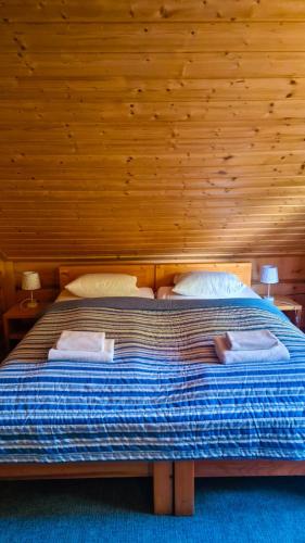 a large bed in a room with wooden walls at Karczma Rybna Rybaczówka Marina B&B in Świnoujście