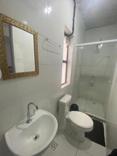 a bathroom with a sink and a toilet and a mirror at Vale do Pontal Angra Suites in Angra dos Reis
