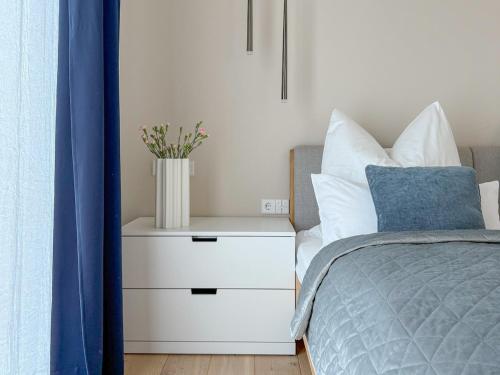 a bedroom with a bed with a vase on a night stand at Ava Lodge am Hainer See in Neukieritzsch
