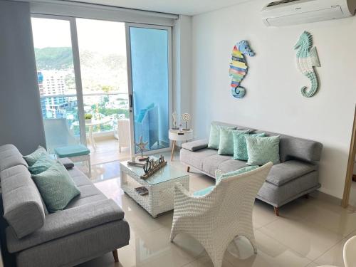 a living room with two couches and a table at Reserva Del Mar Apartamentos in Gaira