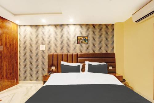 a bedroom with a large bed and two chairs at Super Townhouse OAK The Dev Regency in Patna