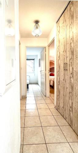a hallway with a large tile floor and a bedroom at Douce parenthèse moderne avec terrasse ensoleillée in Beaudreix