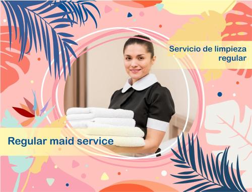 a woman holding a stack of towels in a mirror at LOS CORALES Resort VILLAS & Apartments WIFI BEACH Club & SPA in Punta Cana