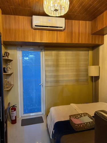 a bedroom with a bed and a window with blinds at Yna's Place - SMDC Tagaytay in Galicias