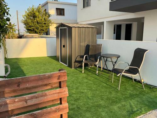 a garden with chairs and a table and a fence at Sunflight Apt 01B One Bedroom Apt in Larnaka