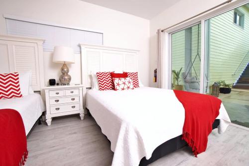 a white bedroom with two beds and a window at The No Problem at Cottages in Sand Bluff