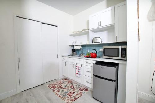a kitchen with white cabinets and a microwave at The No Problem at Cottages in Sand Bluff