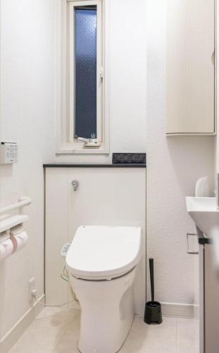a white bathroom with a toilet and a window at Osaka Purestay 5 rooms 2 parking spaces two balconies 8-11 人 Wi-Fi 玉出西 天下茶屋 心斎橋 道頓堀 近い 一 戸建 in Osaka