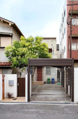 a garage with a gate in the middle of a building at Osaka Purestay 5 rooms 2 parking spaces two balconies 8-11 人 Wi-Fi 玉出西 天下茶屋 心斎橋 道頓堀 近い 一 戸建 in Osaka