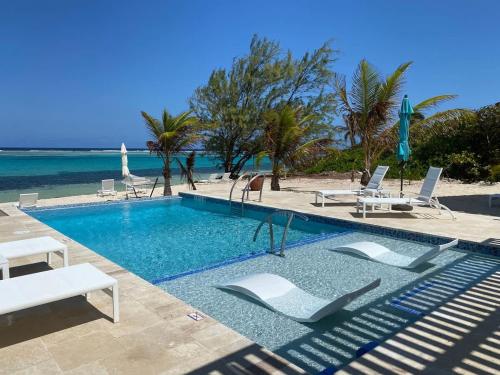 a swimming pool with lounge chairs and the beach at The Sand Dollar at Cottages in Sand Bluff