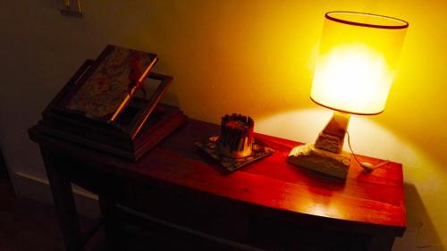a table with a lamp and a picture on it at Attico Barocco in Lecce