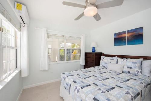 a bedroom with a bed and a ceiling fan at Snug Harbour View Condo #7 in George Town