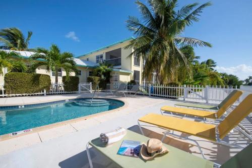 a swimming pool with lounge chairs and a resort at Snug Harbour View Condo #7 in George Town