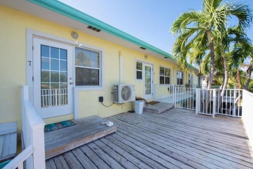 a house with a wooden deck with a door at Snug Harbour View Condo #7 in George Town
