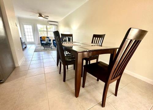 ジョージ・タウンにあるSnug Harbour View Condo #5の木製のテーブルと椅子のあるダイニングルーム