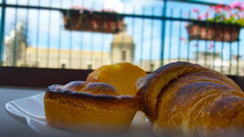 two pieces of bread on a white plate with oranges at Attico Barocco in Lecce