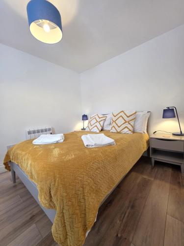 a bedroom with a large bed with a yellow blanket at Cozy One Bed Flat at Dawe Luxury Suites - An Entire Apartment near Ely Cathedral & Train Station - The Perfect Base to Explore Ely, Cambridge, Norfolk & London - 2 Guests Max & Pet Friendly in Ely