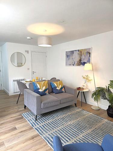a living room with a couch and a table at Cozy One Bed Flat at Dawe Luxury Suites - An Entire Apartment near Ely Cathedral & Train Station - The Perfect Base to Explore Ely, Cambridge, Norfolk & London - 2 Guests Max & Pet Friendly in Ely