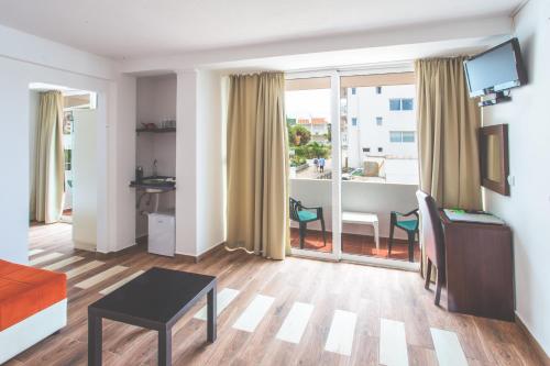 a living room with a couch and a table and a window at David apartments and rooms in Dobra Voda