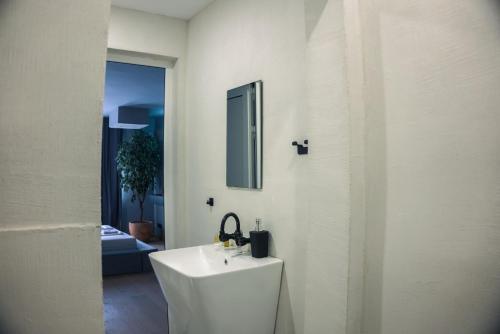 a white bathroom with a sink and a mirror at R34 Boutique Art Hotel in Veliko Tŭrnovo