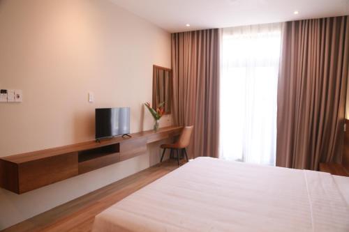 a hotel room with a bed and a television at Soleil Urban Villa in Hue