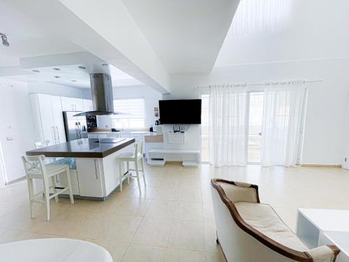 a kitchen with white cabinets and a table and chairs at LOS CORALES Resort VILLAS & Apartments WIFI BEACH Club & SPA in Punta Cana