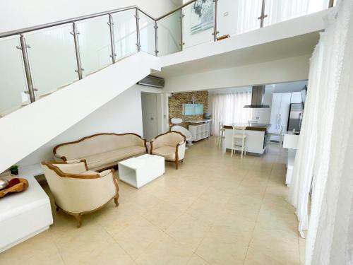a living room with chairs and a staircase at LOS CORALES Resort VILLAS & Apartments WIFI BEACH Club & SPA in Punta Cana