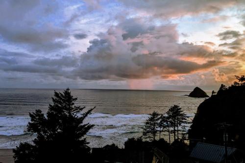 a sunset over the ocean with trees in the foreground at The Blue Door in Oceanside