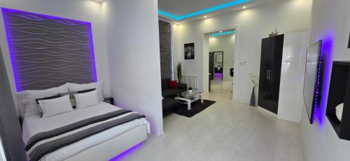 a bedroom with a bed with purple lights on it at Luxury Smart Apartments in Szeged