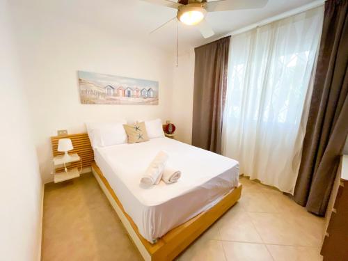 a bedroom with a bed with white sheets and a window at LOS CORALES Resort VILLAS & Apartments WIFI BEACH Club & SPA in Punta Cana