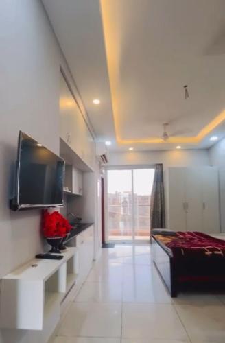 Una habitación con una cama y un televisor en la pared. en Northeye studio, en Noida