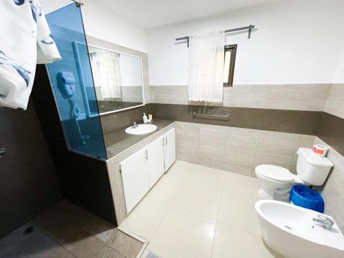 a bathroom with a sink and a toilet and a mirror at LOS CORALES Resort VILLAS & Apartments WIFI BEACH Club & SPA in Punta Cana