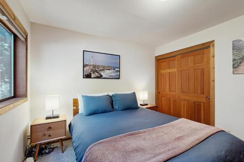 a bedroom with a blue bed and a wooden door at Sequoia Sunset in Gualala