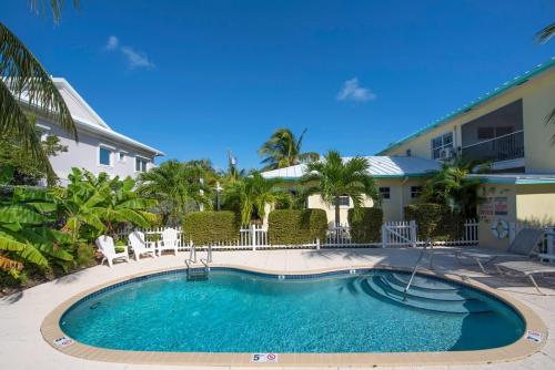 a swimming pool in front of a building with a house at Snug Harbour View Condo #2 in George Town