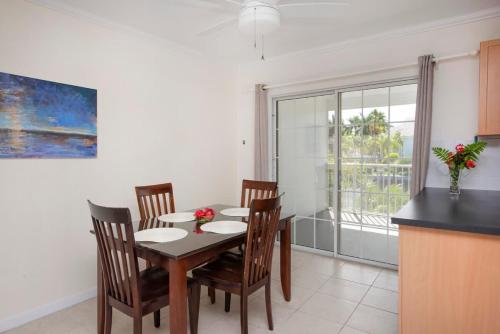a dining room with a table and chairs and a window at Snug Harbour View Condo #9 in George Town