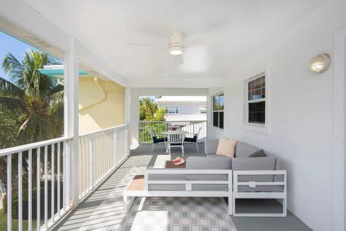 a porch with a couch and a table on a balcony at Snug Harbour View Condo #9 in George Town