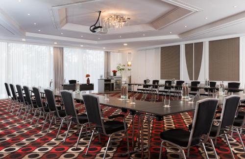 a conference room with a long table and chairs at Leonardo Hotel Munich Arabellapark in Munich