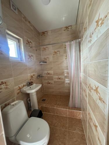 a bathroom with a toilet and a sink at TAMIR House in Tossor