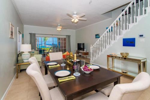 a dining room with a table and white chairs at Northern Lights #4 Condo in Old Man Bay