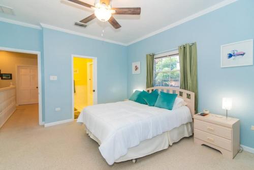a blue bedroom with a bed and a ceiling fan at Northern Lights #4 Condo in Old Man Bay