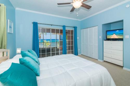 a blue bedroom with a bed and a television at Northern Lights #4 Condo in Old Man Bay