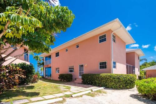 a pink building with bushes in front of it at Northern Lights #4 Condo in Old Man Bay