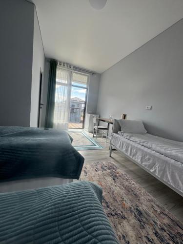 a bedroom with two beds and a table and a window at TAMIR House in Tossor