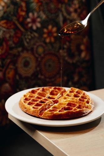 a syrup being drizzled onto a waffle on a plate at Wyndham Garden Barranquilla in Barranquilla