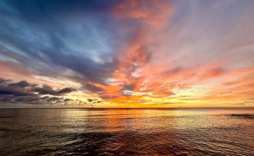 ジョージ・タウンにあるCocoplum #5 Condoの曇り空と海上の夕日