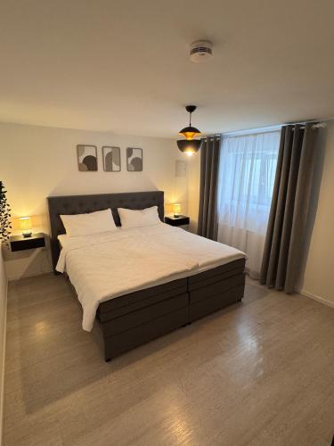 a bedroom with a large bed with white sheets at 2-Zimmer Souterrain Wohnung in Kehl am Rhein