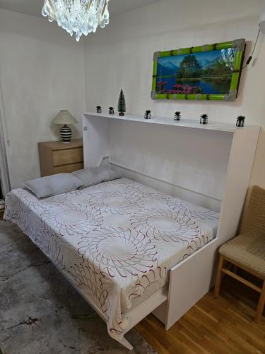 a white bed in a room with a chandelier at Laki 15 in Kalugjerica
