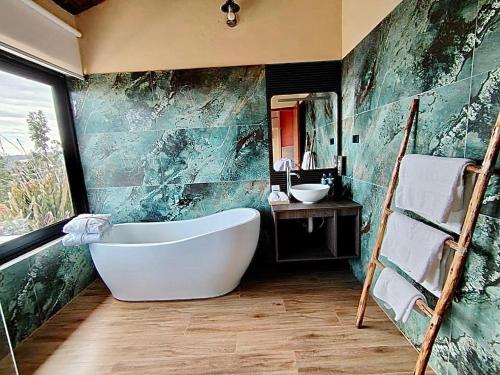 a bathroom with a bath tub and a sink at Altipacha Valley Q Lodge in Quinua